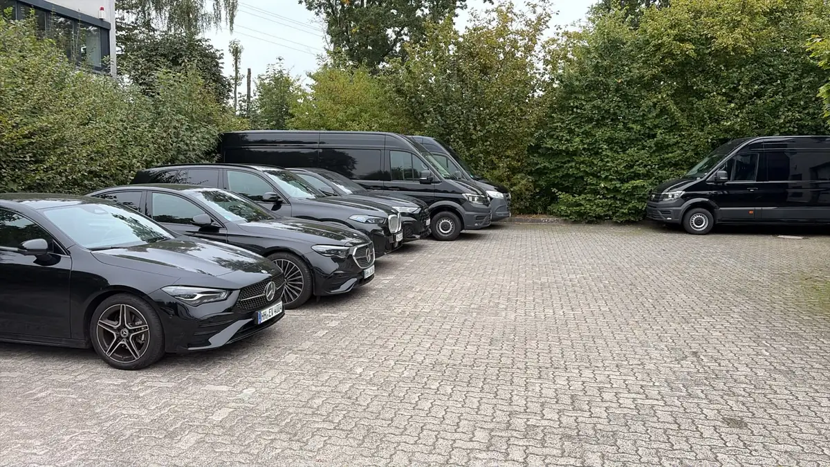 EASYVAN Fahrzeuge auf dem Hof: schwarze Limousinen und Transporter nebeneinander geparkt